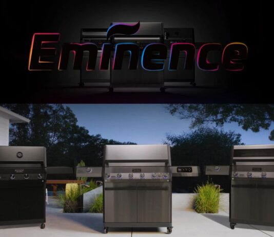 Monument Grills launches new flagship Eminence Series smart gas grills. In this pic is the E405 on a patio in a backyard with evergreens in the background.